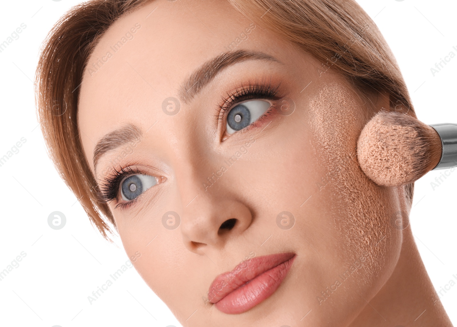 Photo of Beautiful young woman applying face powder with brush on white background, closeup