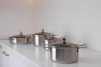 Photo of Set of new clean cookware on countertop in kitchen