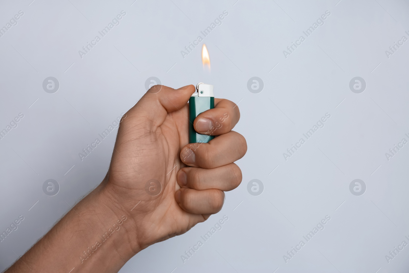 Photo of Man holding lighter on white background, closeup