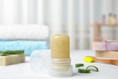 Photo of Natural crystal alum deodorant and aloe on white wooden table