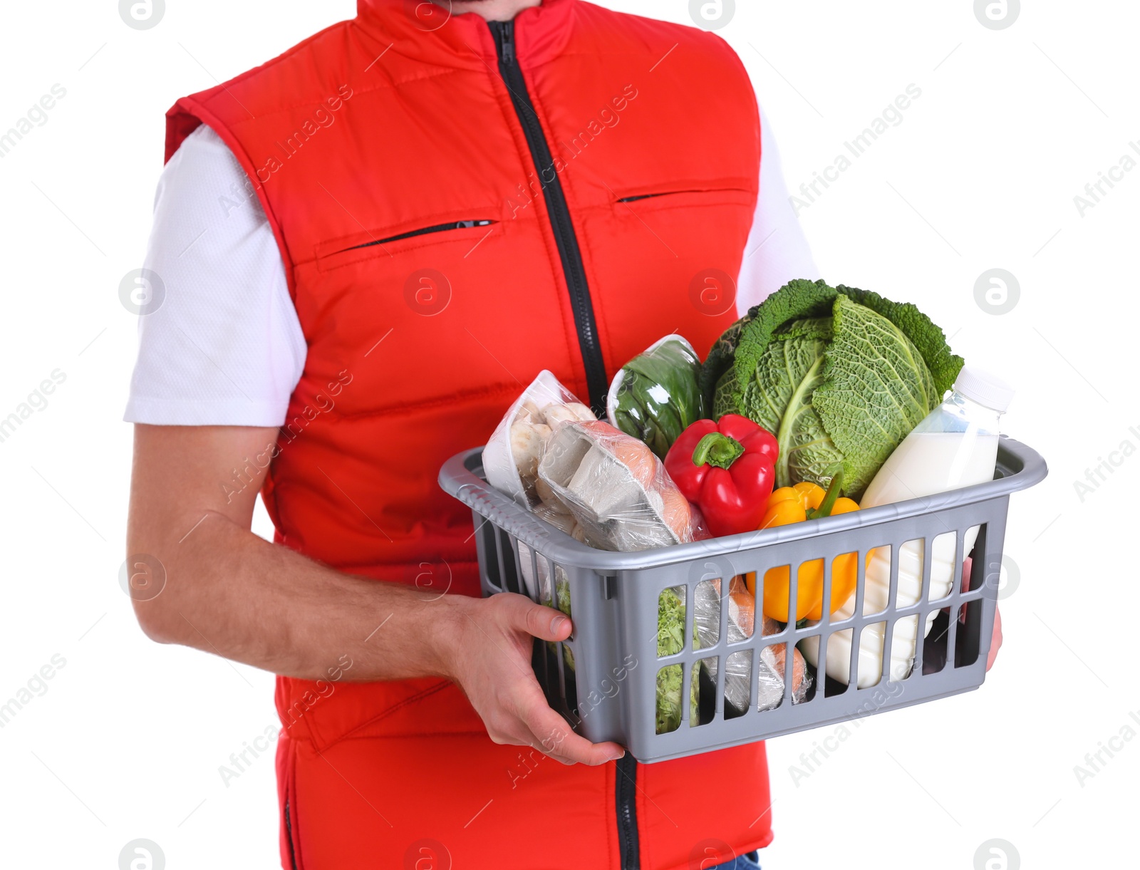 Photo of Delivery man holding plastic crate with food products on white background, closeup