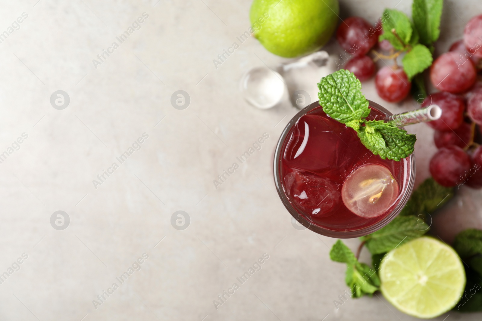 Photo of Refreshing drink with soda water, grapes, lime and mint on light table, flat lay. Space for text