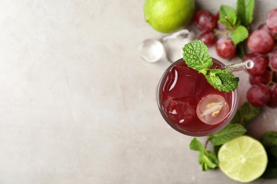 Photo of Refreshing drink with soda water, grapes, lime and mint on light table, flat lay. Space for text