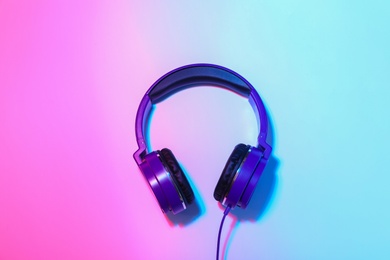 Photo of Stylish headphones on color background, top view