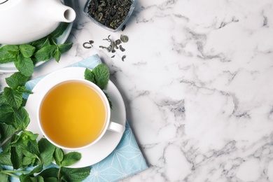 Photo of Fresh tea with mint on white marble table, flat lay. Space for text