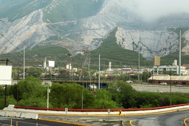 Photo of Picturesque landscape with road and buildings near mountains