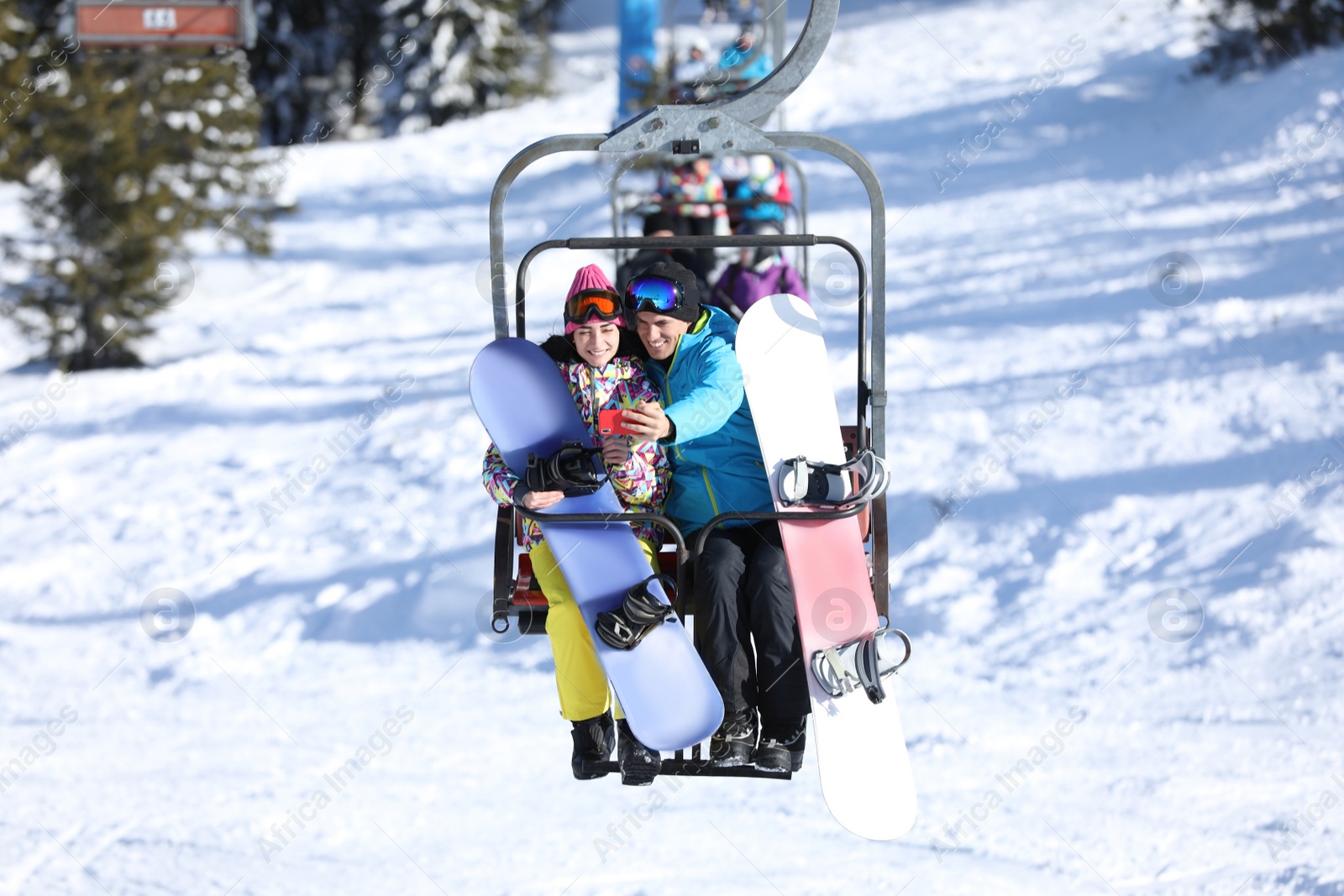 Photo of Couple taking selfie while lifting at mountain ski resort. Winter vacation