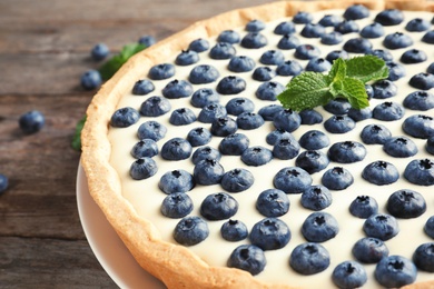 Tasty cake with blueberry on wooden table