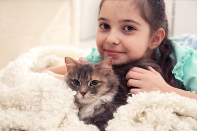 Photo of Cute little girl with cat lying at home. First pet