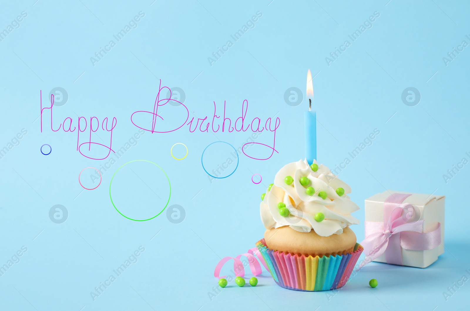 Image of Text Happy Birthday, delicious cupcake with candles and party decor on light blue background