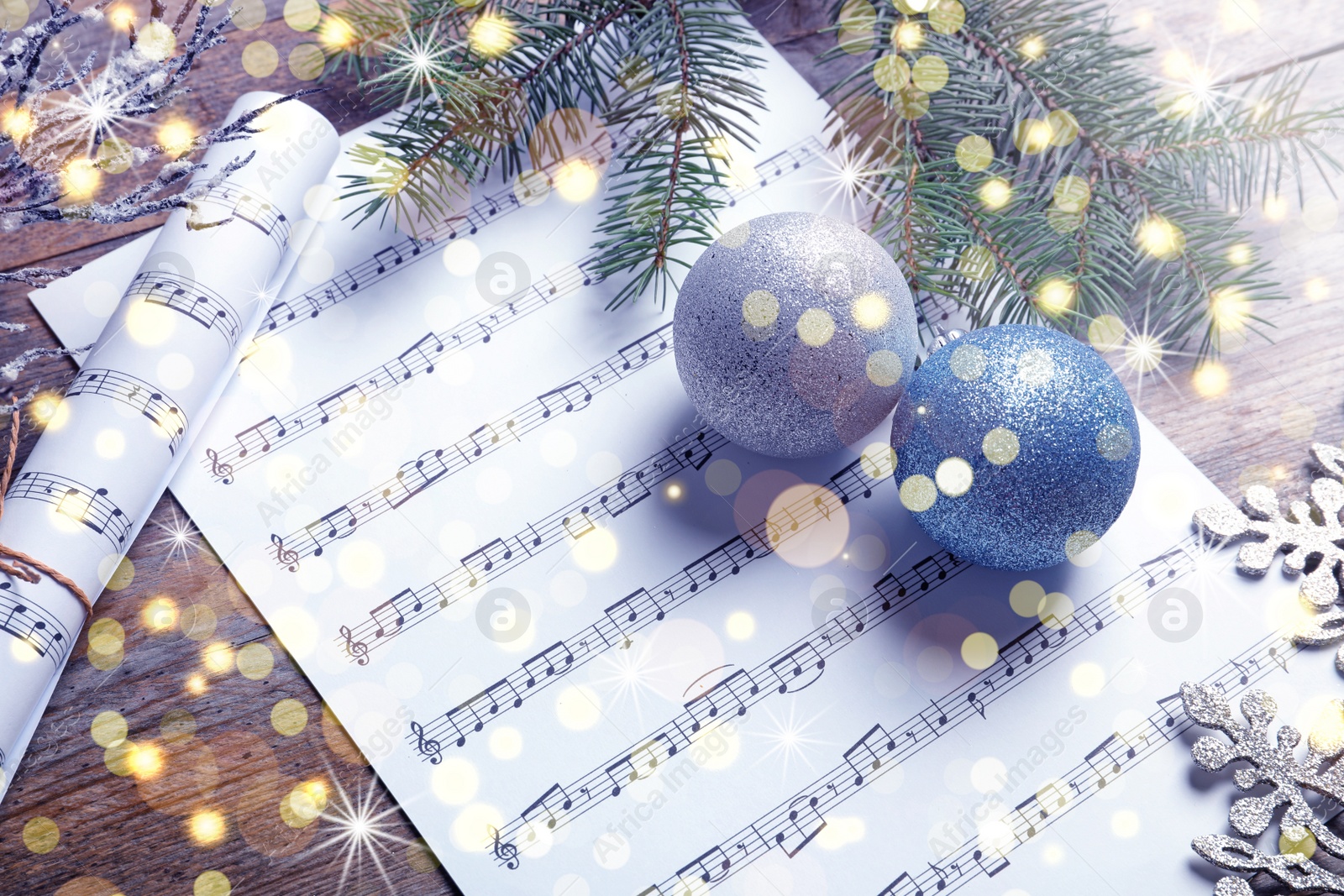 Image of Composition with Christmas decorations and music sheets on wooden background. Bokeh effect