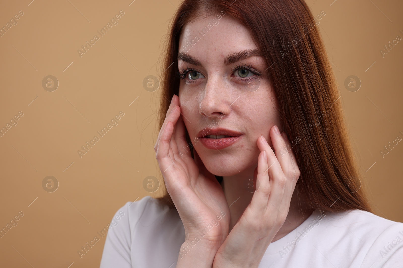 Photo of Portrait of beautiful woman with freckles on beige background. Space for text