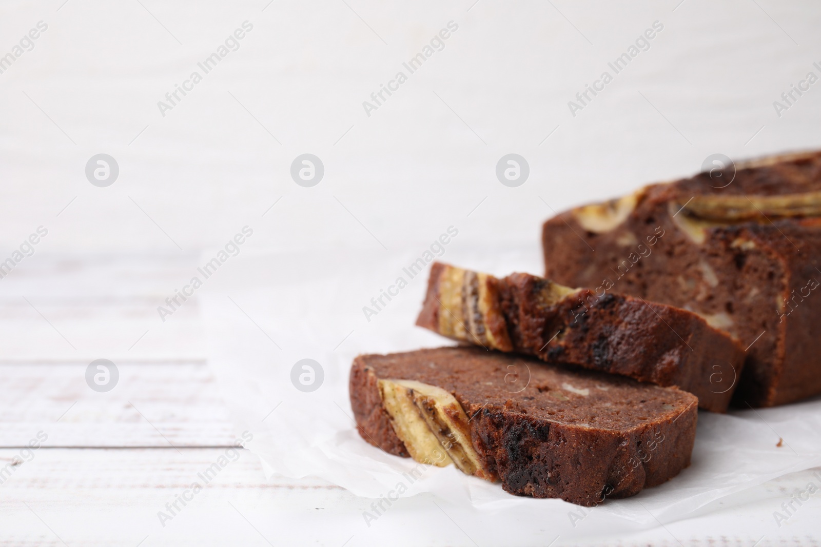 Photo of Delicious banana bread on white wooden table. Space for text