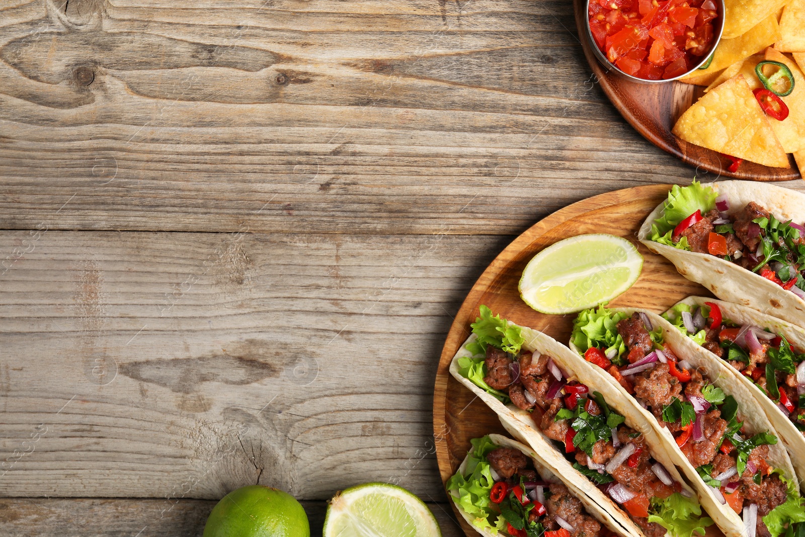 Photo of Flat lay composition with delicious tacos on wooden table, space for text