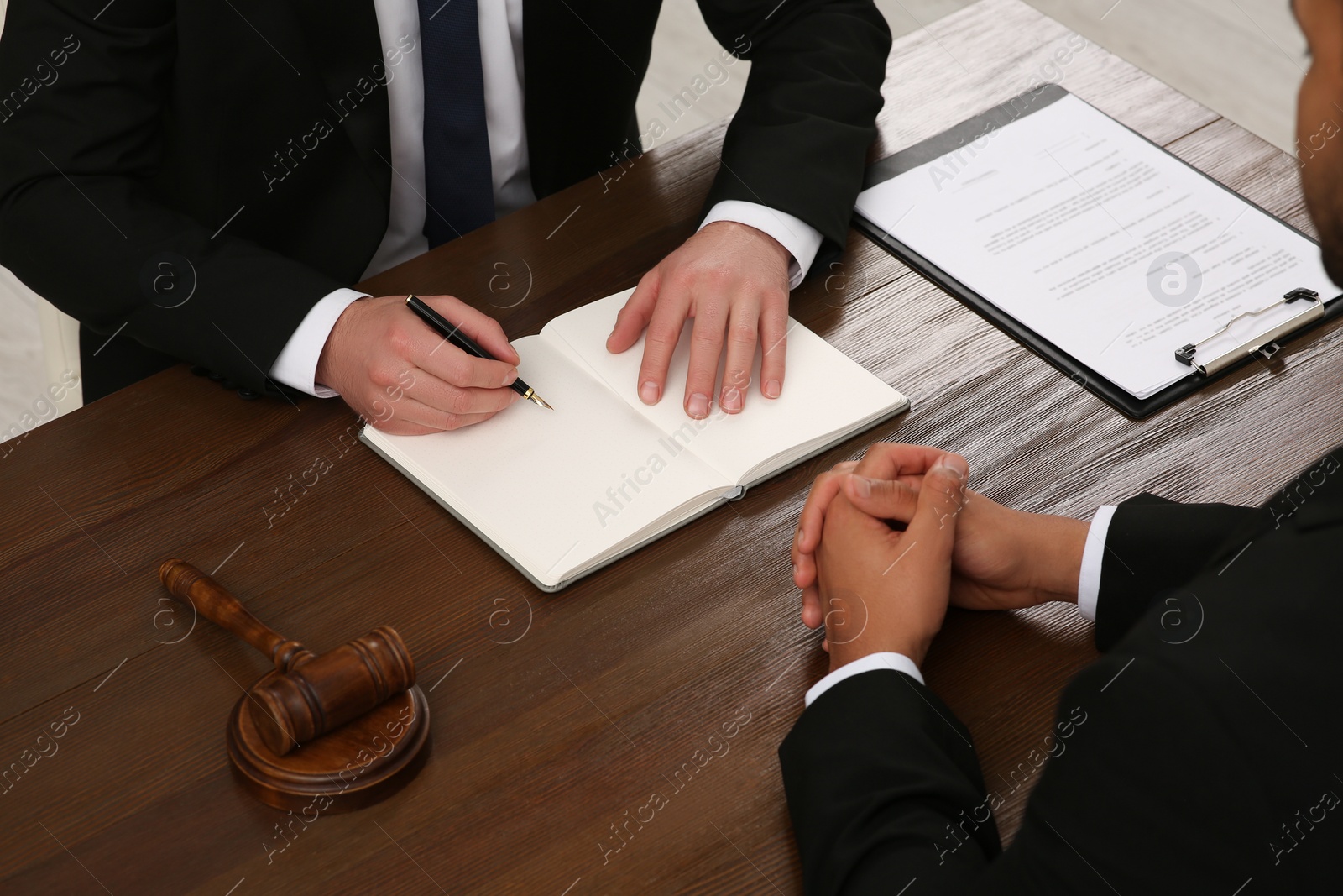 Photo of Law and justice. Lawyers working with documents at wooden table, closeup