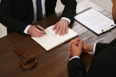 Law and justice. Lawyers working with documents at wooden table, closeup