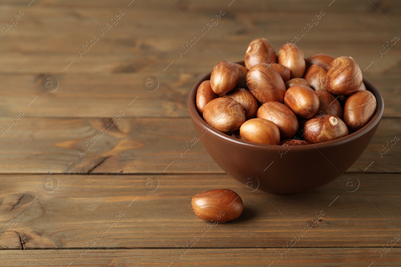 Photo of Bowl of jackfruit seeds on wooden table. Space for text