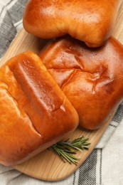 Delicious baked patties with rosemary branches on kitchen towel, top view