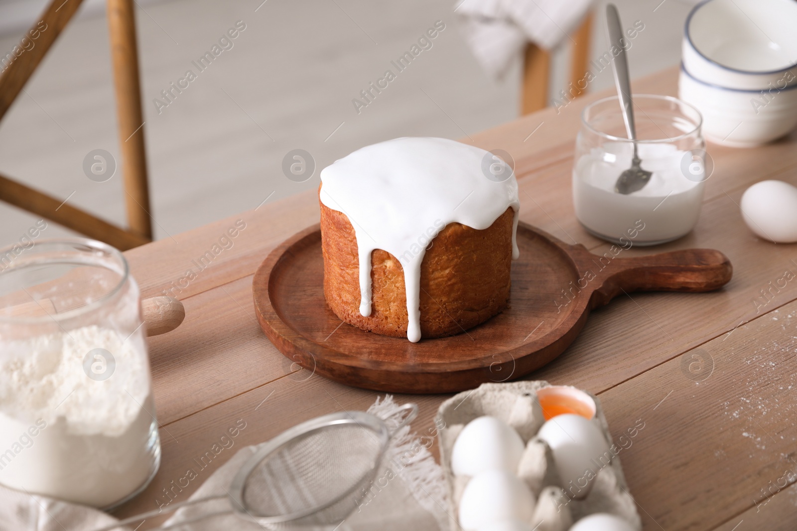 Photo of Traditional Easter cake and ingredients on wooden table indoors