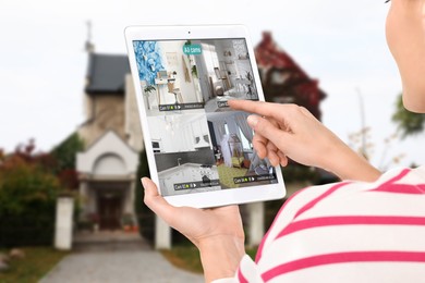 Woman using smart home security system on tablet computer near house outdoors, closeup. Device showing different rooms through cameras