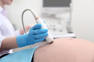 Pregnant woman undergoing ultrasound scan in clinic, closeup