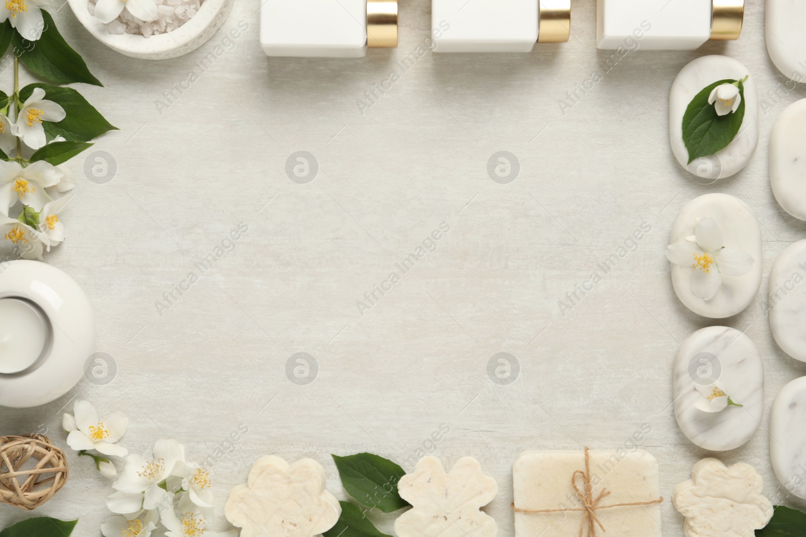 Photo of Jasmine flowers and set of spa essentials on white wooden table, flat lay. Space for text