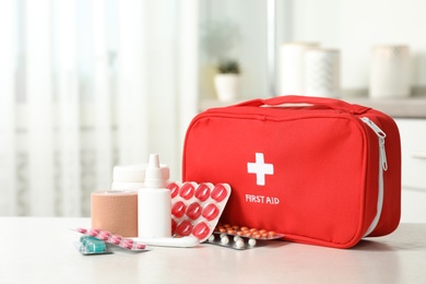 Photo of First aid kit with pills on table indoors