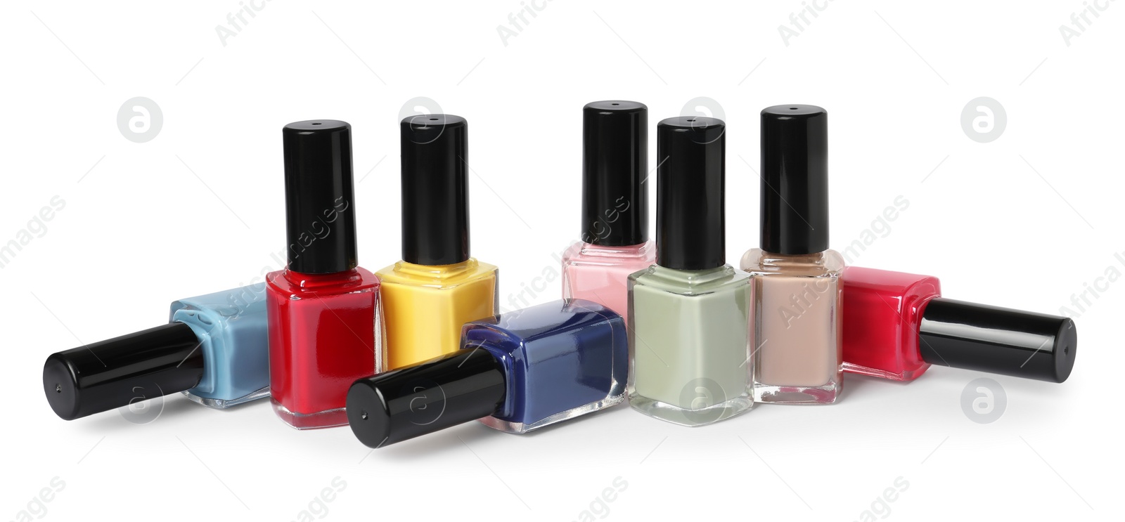 Photo of Bright nail polishes in bottles isolated on white