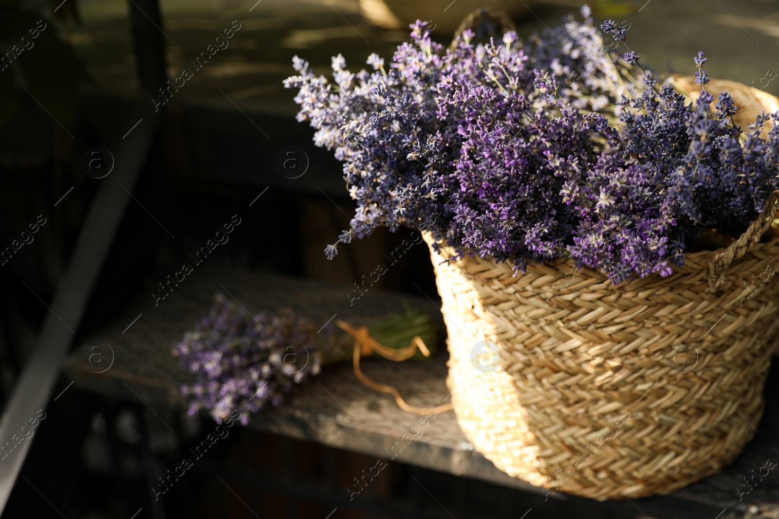 Photo of Wicker basket with beautiful lavender flowers on metal stairs outdoors