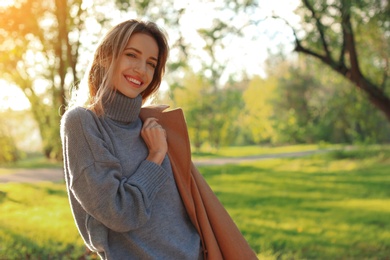 Photo of Beautiful young woman wearing stylish clothes in autumn park