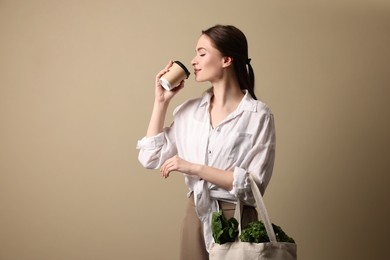 Woman with eco bag and takeaway cup on beige background