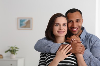 Photo of Dating agency. Man hugging his girlfriend indoors, space for text