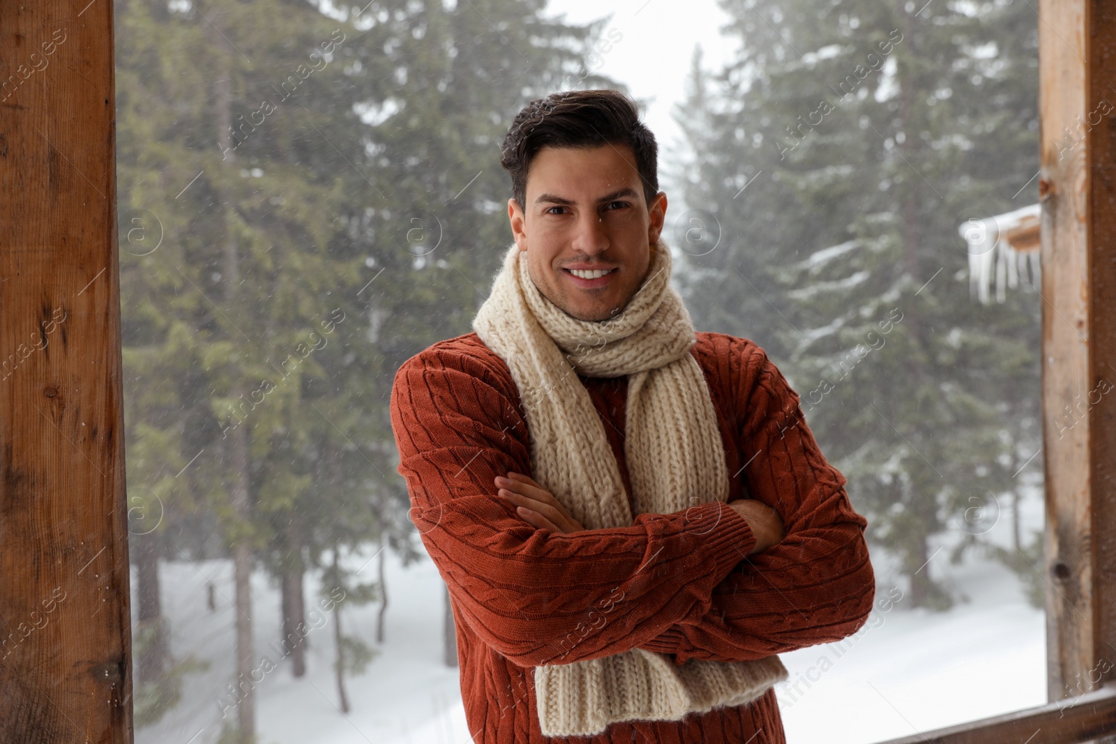 Photo of Handsome man wearing warm sweater and scarf outdoors on snowy day. Winter season