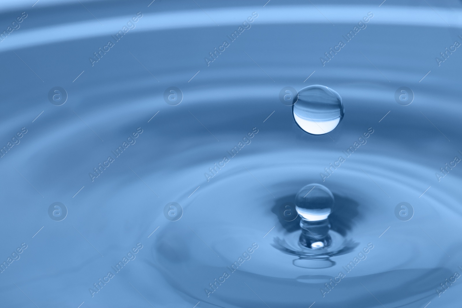 Photo of Splash of clear water with drop on light grey background, closeup. Space for text