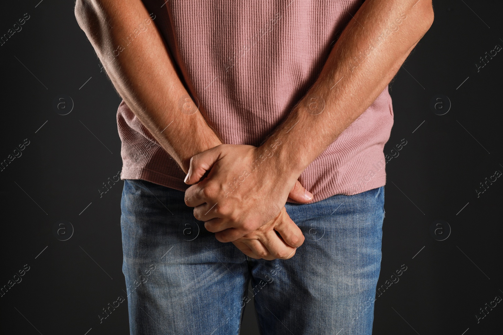 Photo of Man suffering from pain on black background, closeup. Urology problems