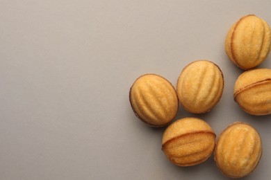 Photo of Homemade walnut shaped cookies with condensed milk on light grey background, flat lay. Space for text