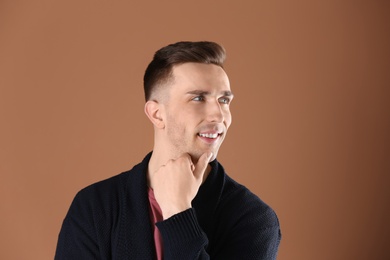 Portrait of young man with beautiful hair on color background