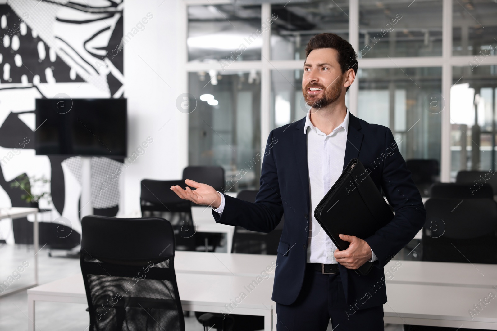 Photo of Happy real estate agent with leather portfolio indoors