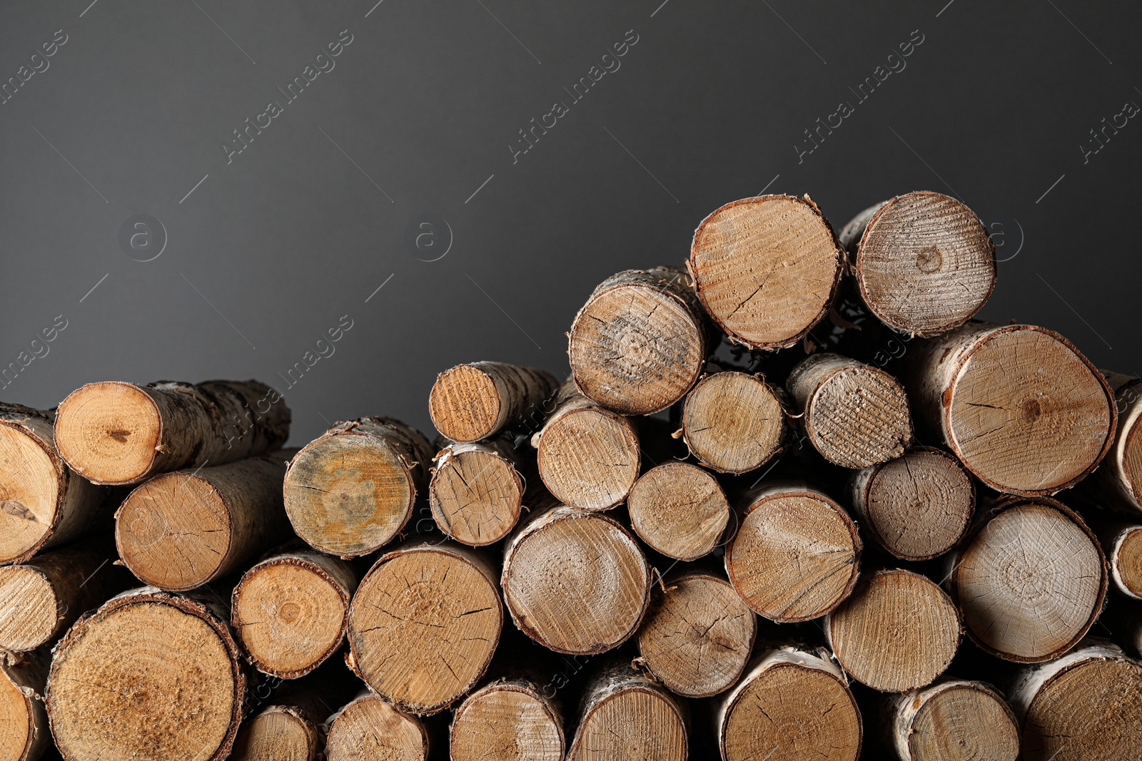 Photo of Cut firewood on grey background. Heating in winter