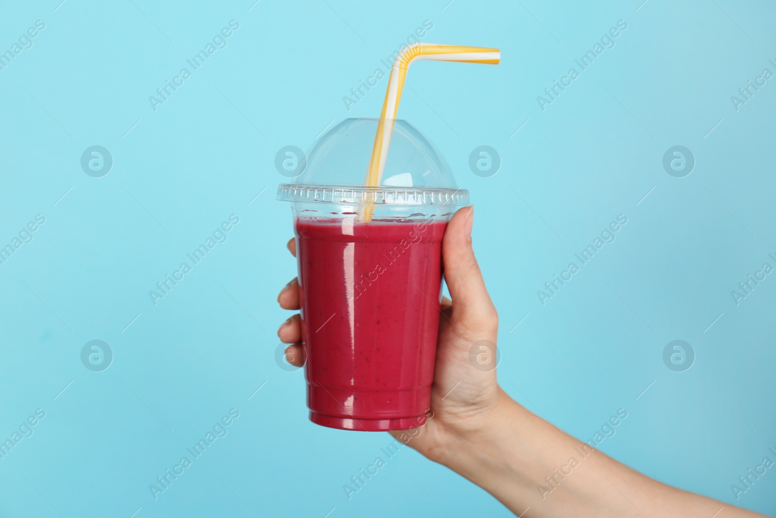 Photo of Woman holding plastic cup with delicious smoothie on color background