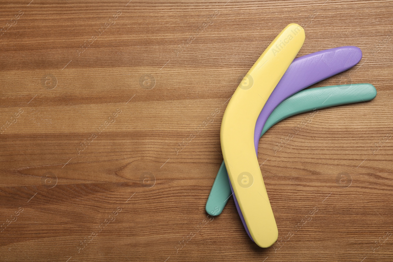 Photo of Boomerangs on wooden background, flat lay. Space for text