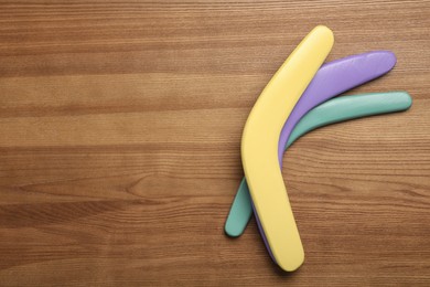 Photo of Boomerangs on wooden background, flat lay. Space for text