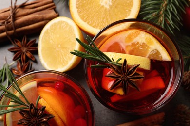 Photo of Delicious punch drink with cranberries, orange and spices on grey table, flat lay