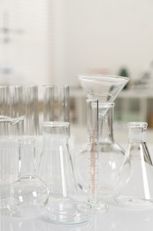 Photo of Laboratory analysis. Different glassware on white table indoors, closeup