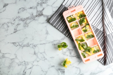 Photo of Flat lay composition with ice cube tray and space for text on marble table