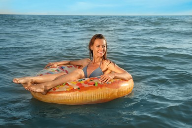 Happy woman with inflatable ring in sea