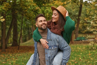 Happy young couple spending time together in autumn park