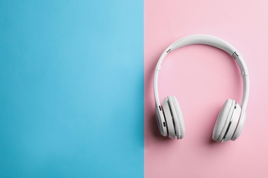 Photo of Wireless headphones on color background, top view. Space for text