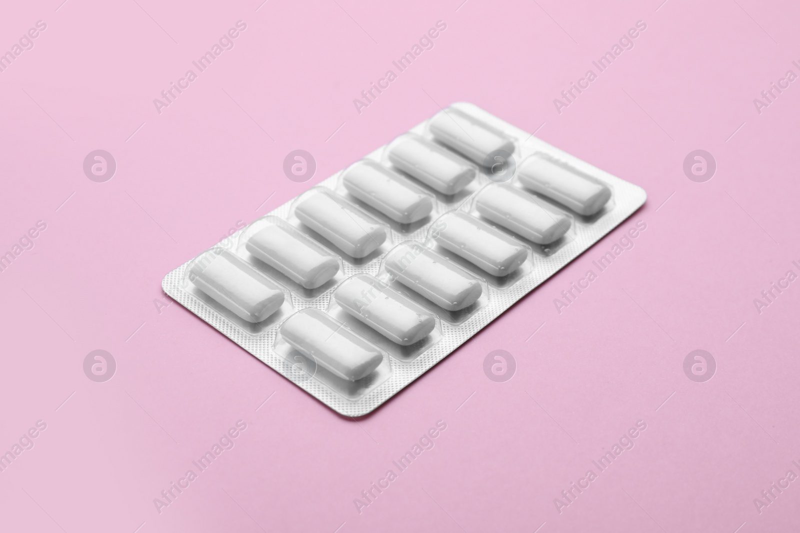 Photo of Blister with chewing gums on pink background