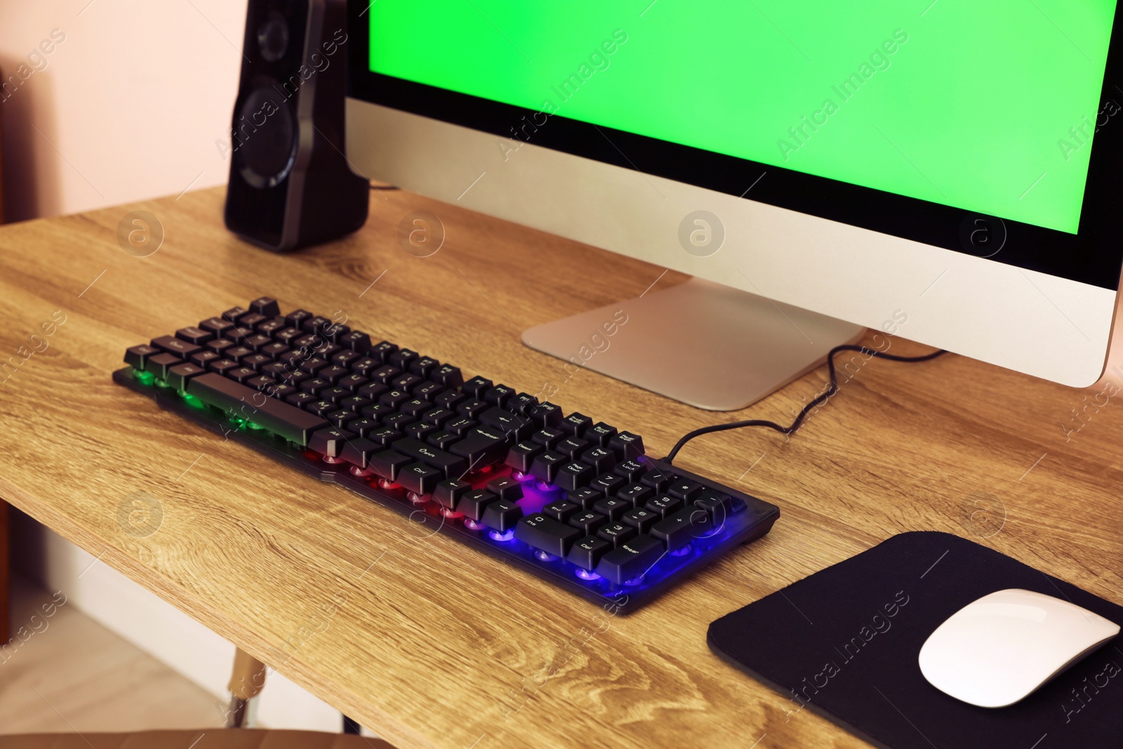 Photo of Modern computer and RGB keyboard on wooden table indoors
